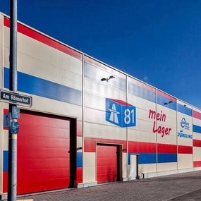 Modernes Selfstorage-Lagerhaus mit rot-blau-weißer Fassade und Beschriftung in Stuttgart.