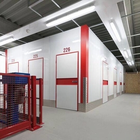 Moderne Selfstorage-Lager mit nummerierten, gesicherten Lagerräumen und Beleuchtung.